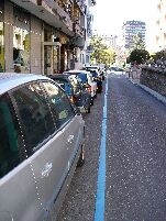 Una calle señalizada con la línea azul de la zona O.R.A.